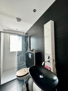 W łazience znajduje się czarna umywalka i prysznic. w obiekcie L'Archipel, belle maison au coeur de Fouesnant w mieście Fouesnant