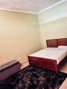 a small bedroom with a bed and a couch at The home hive apartment in Kampala