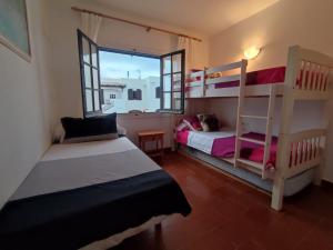 a bedroom with two bunk beds and a window at Apartamento Menorca son parc in Son Parc