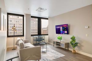 a living room with a couch and a table at Sky High Luxury - 10th Floor - PRIME LOCATION CITY VIEWS FAST WIFI 24-7 Gym Lounge Roku in Pittsburgh