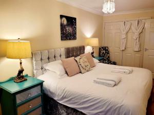 a bedroom with a white bed with a lamp on a table at Apartment 2 in Darlington