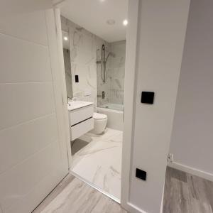 a white bathroom with a toilet and a sink at Smart Central Birmingham 1 Bed Apartment in Birmingham