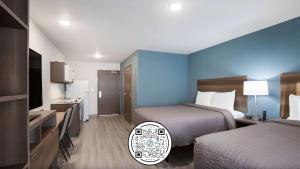 una camera d'albergo con due letti e una televisione di WoodSpring Suites Libertyville - Chicago a Libertyville