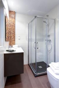 y baño con ducha de cristal y aseo. en Apartamentos La Albarca, en Hoznayo