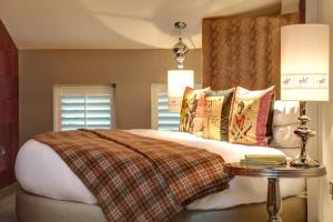 um quarto com uma cama grande e uma mesa em Oddfellows Chester Hotel & Apartments em Chester