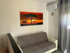 una sala de estar con sofá y una pintura en la pared en Stranizza D'amari, en Erice