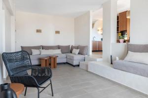 uma sala de estar com um sofá e uma cadeira em Casa di Demezzo em Sitia