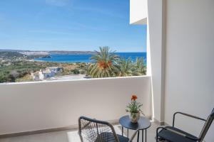 a balcony with a table and chairs and a view of the ocean at Casa di Demezzo in Sitia