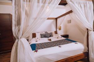 ein Schlafzimmer mit einem Bett mit weißen Vorhängen in der Unterkunft Elixir Woods Luxury Resort And Spa, Munnar in Munnar