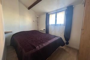 ein kleines Schlafzimmer mit einem Bett und einem Fenster in der Unterkunft Maisonette by the sea in Frontignan