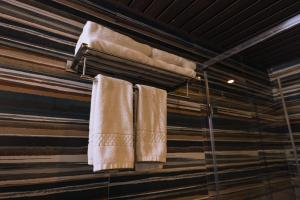 ein Bad mit drei an der Wand hängenden Handtüchern in der Unterkunft Elixir Woods Luxury Resort And Spa, Munnar in Munnar