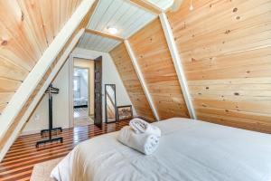 ein Schlafzimmer mit einem Bett in einem Zimmer mit Holzwänden in der Unterkunft A-Frame Catskills Cabin with Scenic Views and Hot Tub! in Stamford