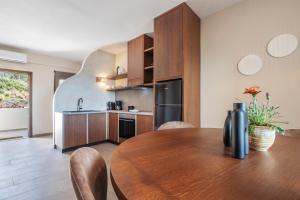 uma cozinha e sala de jantar com uma mesa de madeira em Casa di Demezzo em Sitia