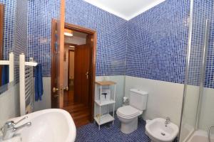 a blue tiled bathroom with a toilet and a sink at Atlantic Dream View - Apartment for 4 with amazing sea views in great location in Nazaré