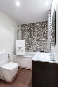 a bathroom with a toilet and a sink and a tub at Apartamentos La Albarca in Hoznayo