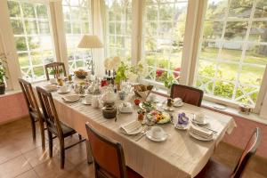 a dining room table with a white table cloth and chairs at Adami Country Guesthouse in Vainupea
