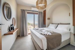 a bedroom with a bed with a view of the ocean at Casa di Demezzo in Sitia