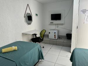 レシフェにあるCasa Recife Pousadaのテーブルとテレビ付きの病室です。