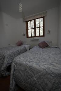 Duas camas num quarto com uma janela em Refugio Atreyu em Santiago