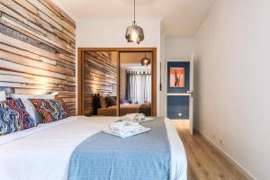 ein Schlafzimmer mit einem Bett mit einer blauen Decke in der Unterkunft Vita Portucale ! Costa Caparica Decor in Costa da Caparica