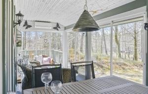 a dining room with a table and a large window at 2 Bedroom Awesome Home In Örkeljunga in Orkelljunga
