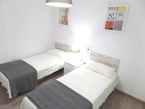 a room with two beds and a table in it at Room City Estepona Castillo in Estepona