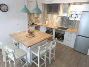 a kitchen with a wooden table and white appliances at Room City Estepona Castillo in Estepona +14 photos