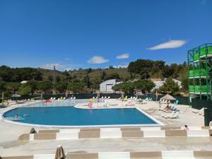 una gran piscina con gente sentada a su alrededor en Mobil-Home pour 6 personnes (3 chambres) en Narbonne
