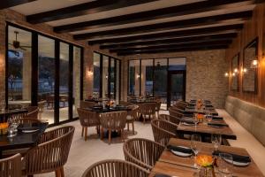 a restaurant with tables and chairs and windows at Casitas At The Hoodoo Moab, Curio Collection By Hilton in Moab