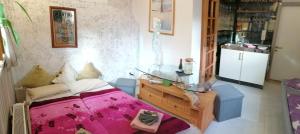 a bedroom with a bed and a table and a refrigerator at Kleines Studio im Eichenwäldchen, 1 Zimmer Küche Bad in Friedrichsgrün