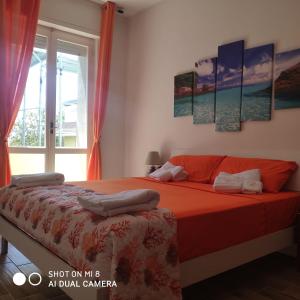 a bedroom with a bed with red sheets and a window at Da Mariolina in Alghero