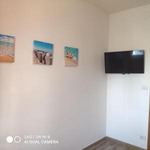 een muur met vier foto's aan een muur bij Da Mariolina in Alghero