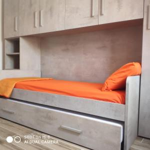 een bed in een kamer met een oranje laken bij Da Mariolina in Alghero