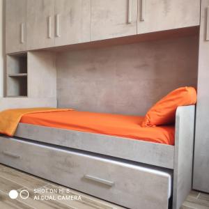 a bed in a room with an orange sheet at Da Mariolina in Alghero