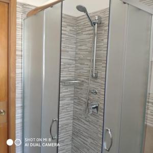 een douche met een glazen deur in de badkamer bij Da Mariolina in Alghero