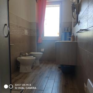 een badkamer met een toilet, een wastafel en een raam bij Da Mariolina in Alghero