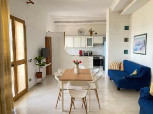 sala de estar con mesa y sofá azul en Villa Mare Giuggiola, en Alcamo Marina