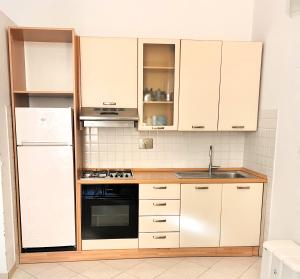a kitchen with white cabinets and a sink at cvr 3- Monolocale luminoso a due passi dalla Torre in Pisa