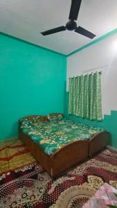 Cama en habitación con pared azul en Gyanbhumi Homestay Ayodhya, en Faizābād