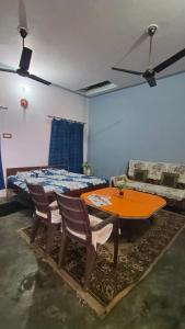 Habitación con mesa, sillas y cama en Gyanbhumi Homestay Ayodhya, en Faizābād