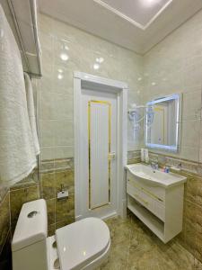 ein Badezimmer mit einem weißen WC und einem Waschbecken in der Unterkunft Arslan Boutique Hotel in Xiva
