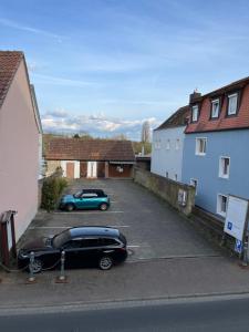 a car parked in a parking lot next to a house at Pension Main-Art in Mainstockheim