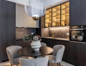 a kitchen with a table with chairs and a vase with flowers at Aglaya 1 - Luxury 2BR Apartment in Belgrade +16 photos