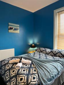 a bedroom with blue walls and a bed at Winter Gardens Flat 3 - Family Apartment in Blackpool