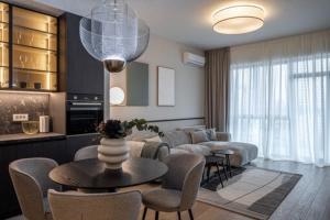 a living room with a couch and a table and chairs at Aglaya 1 - Luxury 2BR Apartment in Belgrade