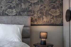 a bedroom with a bed and a table with a lamp at Aglaya 1 - Luxury 2BR Apartment in Belgrade