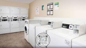 eine Waschküche mit weißen Waschmaschinen und Schränken in der Unterkunft WoodSpring Suites St Louis Arnold in Arnold