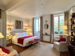 a bedroom with a large bed and two chairs at Le Clos Saluces in Avignon