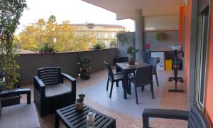 a patio with a table and chairs on a balcony at Bella Recanati Apartment a Giardini Naxos in Giardini Naxos