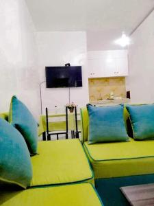 a room with green and blue couches and a tv at My Lovely Apartment in Dipolog